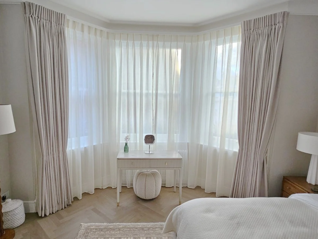 Bespoke curtains and sheer window panels fitted in a bright modern bedroom